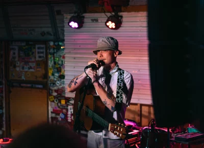 Singer-songwriter Quinn Christopherson speaking to the crowd, talking about his day, and the heat in Salt Lake City, compared to his hometown in Alaska.