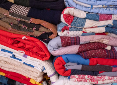 A large stack of quilted fabrics