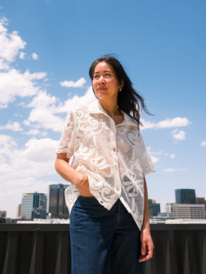 Deedee stands backdropped by a blue sky.