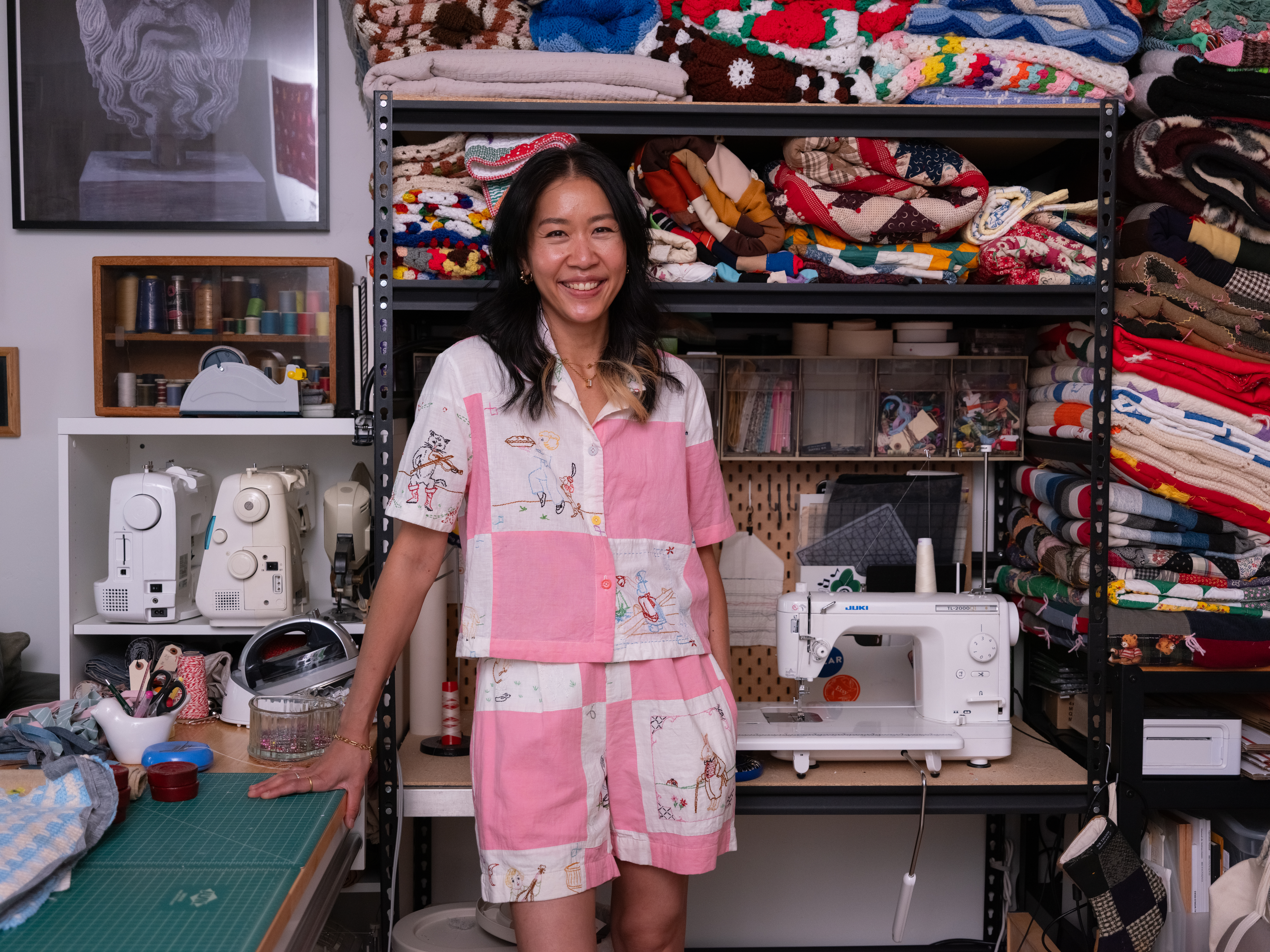 Deedee in her studio surrounded by clothes