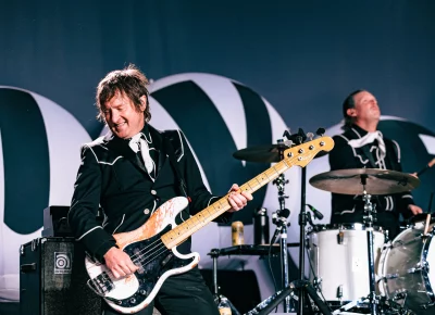 Bassist Mattias Bernwall smiling and playing with The Hives in Salt Lake City, UT.