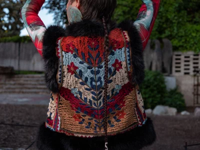 Diaz showing off the back design of a floral knitted vest.