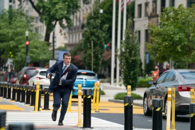 Man running in the city with a gun.