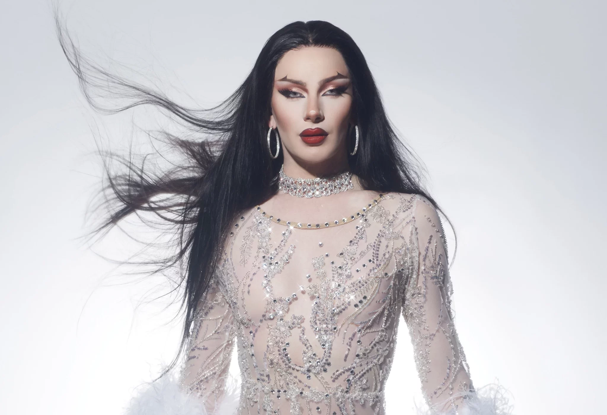 A lady standing in from of a white background.