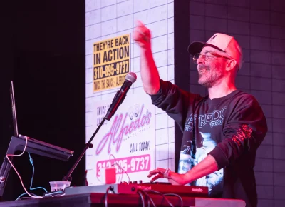 The Alchemist smiles from behind the booth on stage at The Union on Nov. 1.