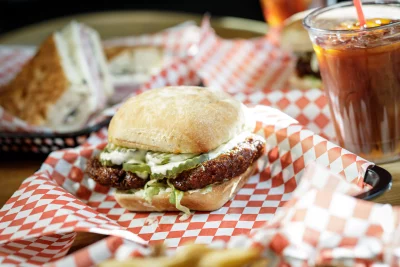 the honey buffalo chicken sandwich sitting on a tray with red and white checkered paper underneath