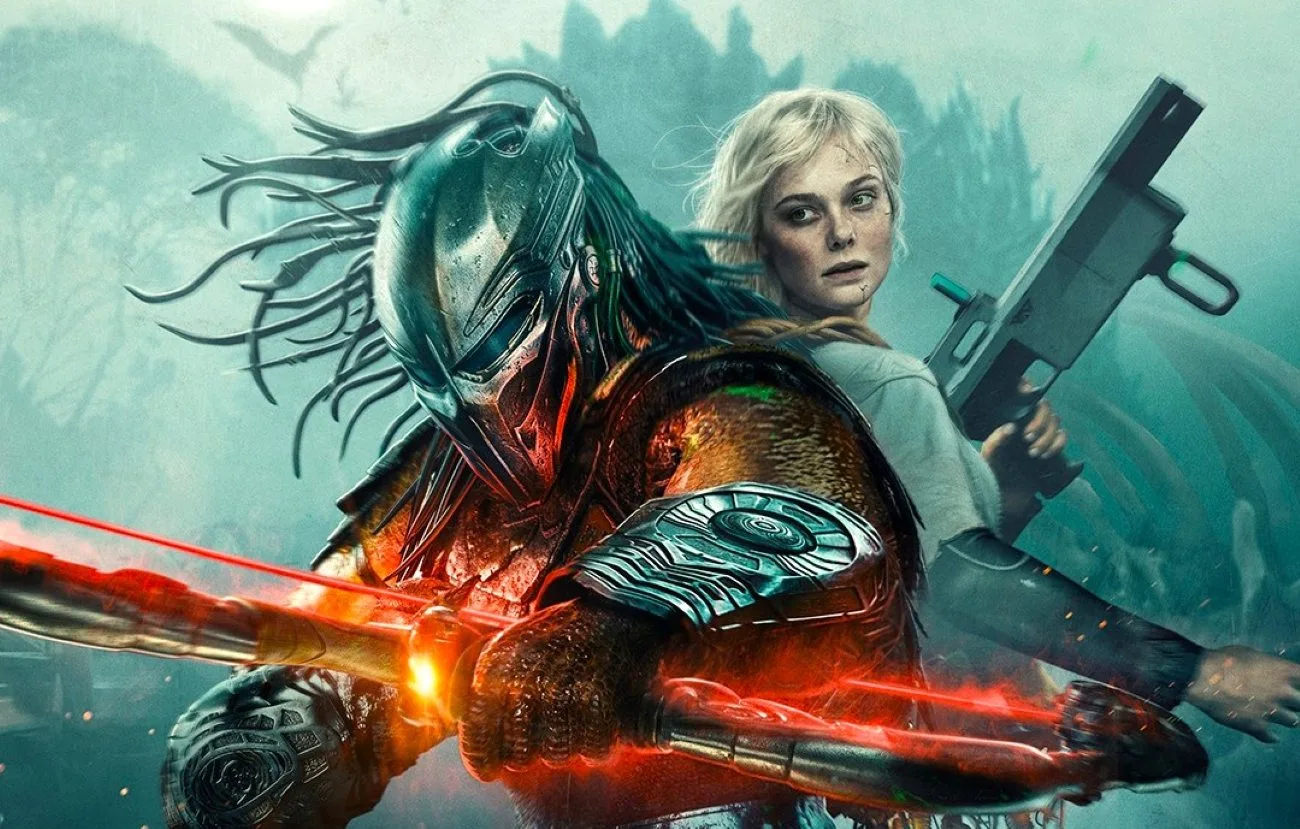 The Predator and Elle Fanning stand back-to-back holding weapons