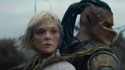 Elle Fanning and the Predator stand back to back. Courtesy of Lawrence Gordon Productions