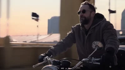 Actor Noah Wyle riding a motorcycle without a helmet in the opening scene of The Pitt season two.