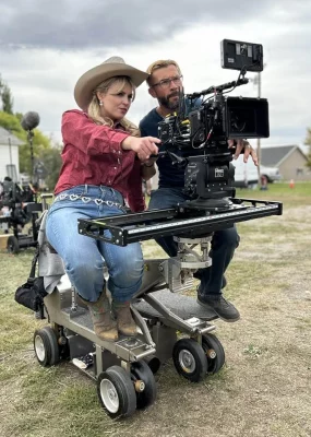 Filmmaker Savannah Ostler handling a camera on-set while filming Buster Brooks.