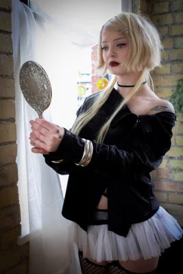 Kate Johnson looks into a hand mirror