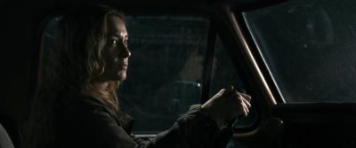 Film still from Shelby Oaks: Camille Sullivan at the steering wheel in a dark car.