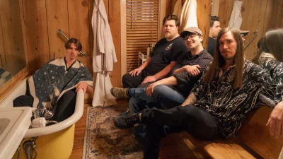 The band Modern Speed sitting in a bathroom with one bandmate sitting in a bathtub.