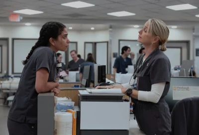 Two woman nurses talking at a desk.