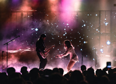 Cannons guitarist Ryan Clapham and singer Michelle Joy singing and dancing towards each other