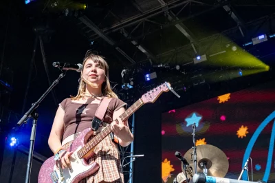 A girl with a guitar on stage.