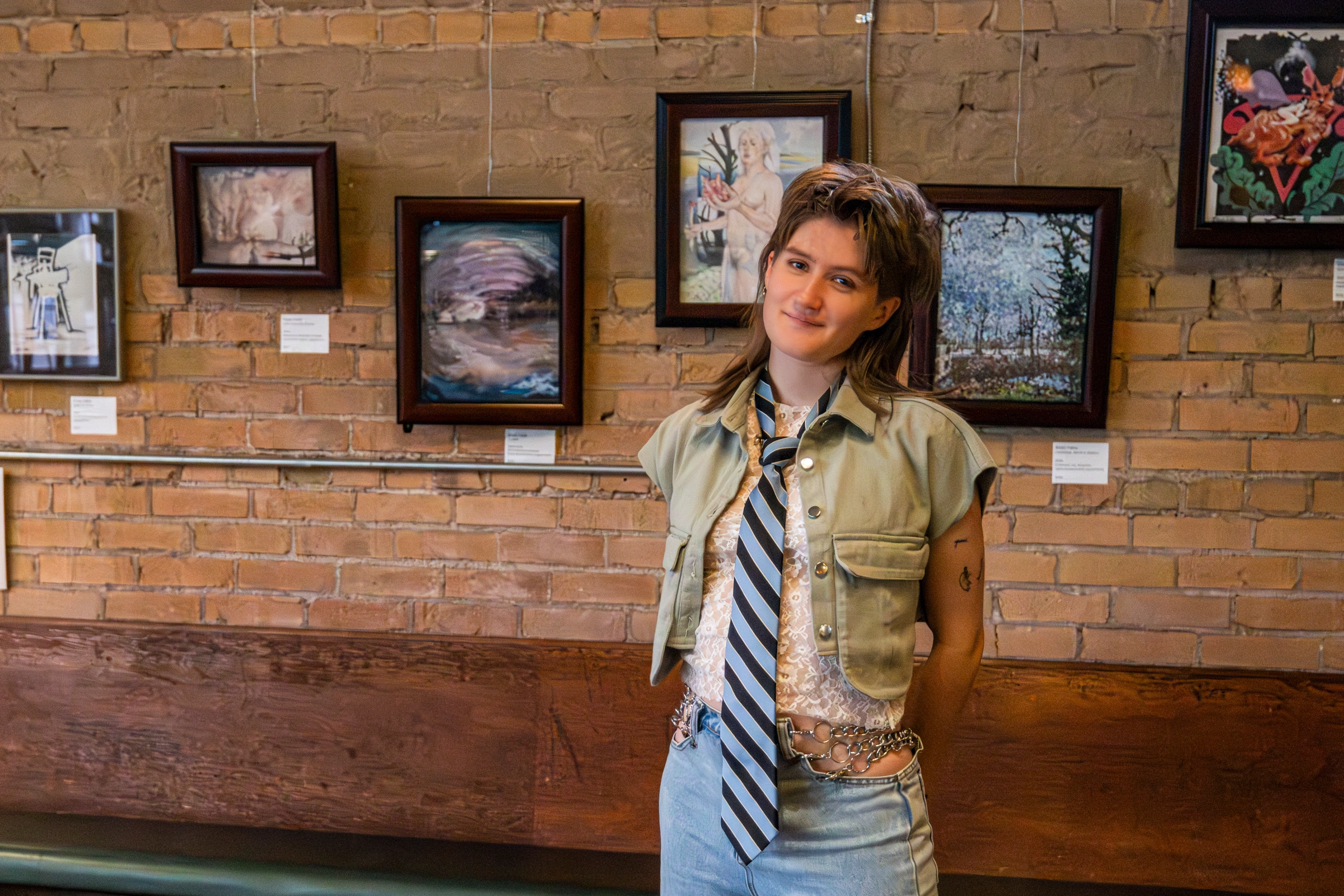 Elijah June posing in front of their art