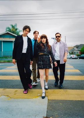 Four bandmates walking through a crosswalk.