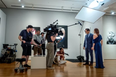 Cast and crew recording a scene in an art gallery.