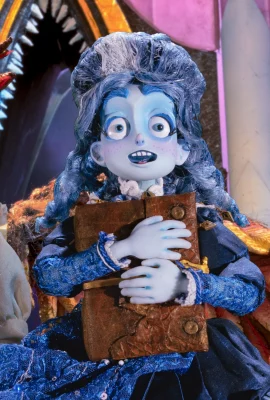A scene from Netflix's newest stop-motion release, Soy Frankelda. Frankelda stands clutching her book with a smile.