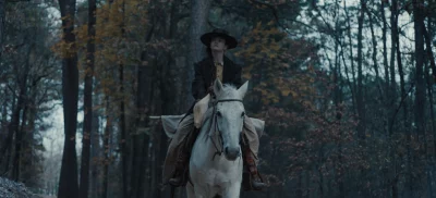 MacKenzie Foy on a horse in a wooded area in The Isolate Thief.