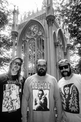 Three guys standing in a cemetary