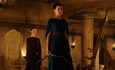 Two women in a darkly-lit room.
