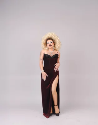 Veronika DaVil posing in a black dress against a white backdrop
