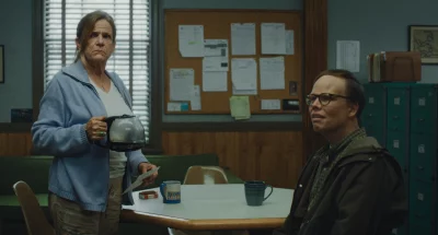 Two people in a break room getting coffee.