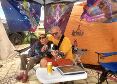 Camper plays his guitar in awesome tent setup. Photo: Kyle Aldridge